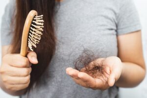 Femeie care se confruntă cu simptome provocate de un dezechilibru hormonal
