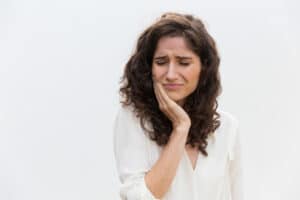 Persoană cu dinți sensibili care simte durere la consumul unei băuturi reci